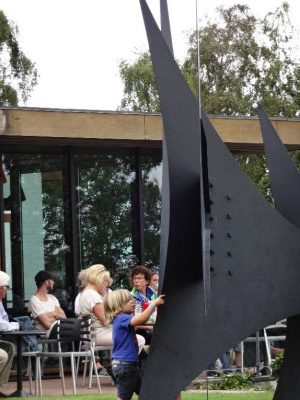 Un jeune danois touche une sculpture dans le jardin de Louisiana, musée d'Art Moderne au Danemark.
