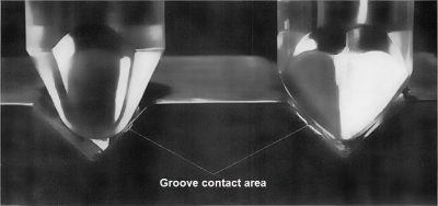 Source : vinylengine.com photo d'une pointe sphérique et d'une pointe elliptique dans un sillon de vinyle