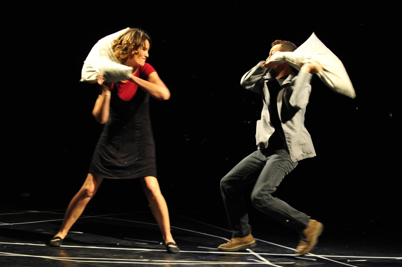 un homme et une femme souriants se jettent des coussins à la figure